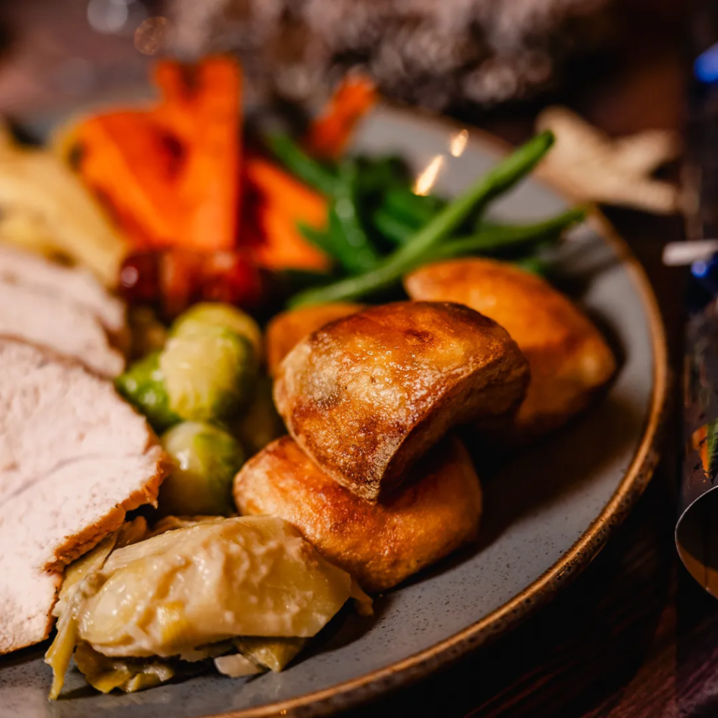 Hand Carved Turkey Breast With Plenty of Roasties Traditional turkey with sage & onion stuffing, chipolata pig in blanket and rich gravy. Served with roasted potatoes, Brecon honey roasted parsnip, Welsh buttered Brussels sprouts, carrots & spiced braised red cabbage.