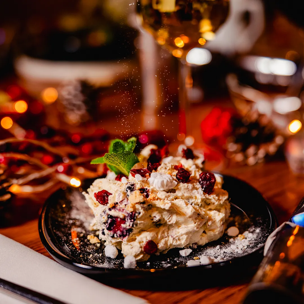 Snowball Smash Crushed meringue with cranberry, blackcurrants & crème de mûre, crunchy amaretti & cinnamon whipped cream.